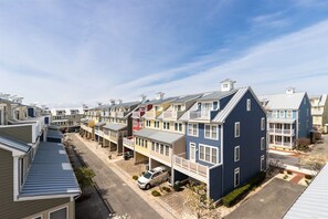 A row of townhouses with attached porches, a clear sky, and a street in the foreground. - Sunset Island 3 Fountain Drive West (Ocean City)