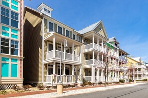 A row of multi-story buildings with balconies and a clear sky.