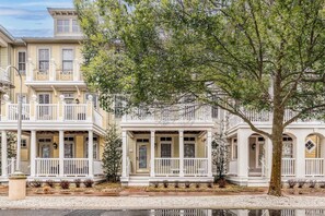 A row of two-story townhouses with white railings and a central tree. - Sunset Island 17 Island Edge Drive (Ocean City)