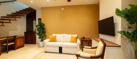 A modern living room with a white sofa, wooden coffee table, and a ceiling fan.