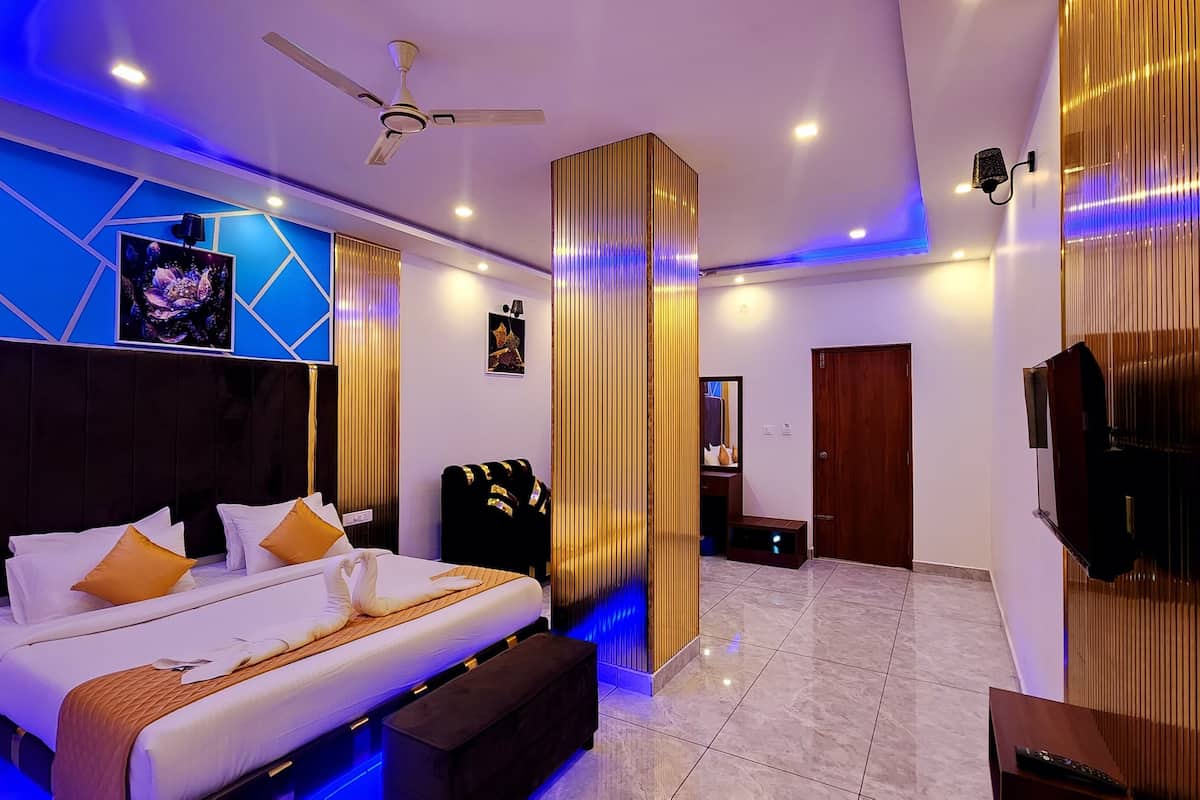 Un dormitorio moderno con cama, ventilador de techo y televisión.
