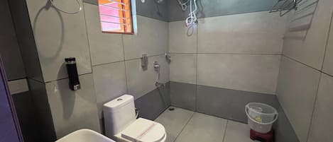 A small bathroom with a toilet, sink, and shower.