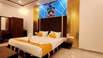A hotel room with a large bed, a wooden wardrobe, a mirror, and a wall-mounted artwork.