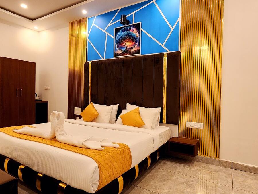 A hotel room with a large bed, a wooden wardrobe, a mirror, and a wall-mounted artwork.