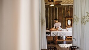 Et spa-værelse med træloft, seng, spejl og en lanterne.