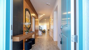 Un couloir moderne avec un banc en bois, un miroir et un escalier en arrière-plan.