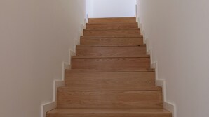 Eine Treppe mit Holzbodenstufen und weißen Wänden.