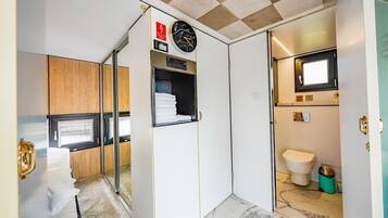 Uma casa de banho compacta com sanita, lavatório e espelho.