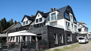 A modern two-story house with a balcony, large windows, and a garage. - Apartment in Mrzeżyno near Sandy Beaches (Mrzeżyno)