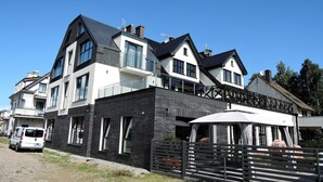 Een modern huis met twee verdiepingen, een balkon, een garage en een overdekt terras.