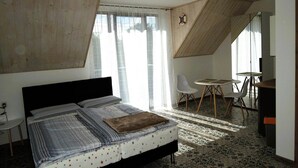 Een slaapkamer met een bed, een bureau en een stoel.
