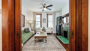A living room with a green sofa, a wooden coffee table, and a fireplace. - German Charm 2 Sophistication! (Columbus)