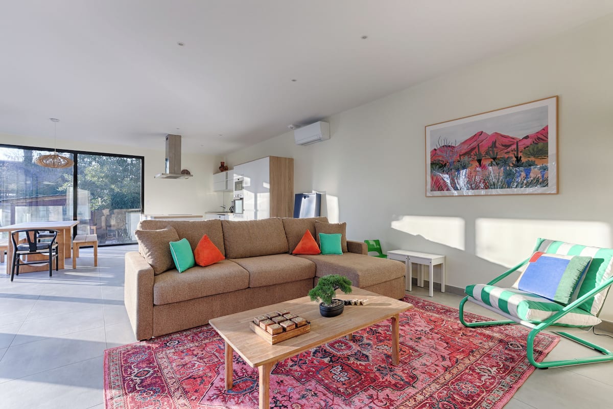Una sala de estar moderna con un sofá, una mesa de centro y una alfombra colorida.