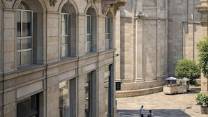 Een historisch gebouw met klassieke architectuur, inclusief een koepel en gebogen ramen.