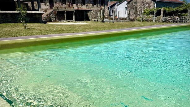 A clear pool with a stone building in the background. - O lagar de Jesús (Padron)
