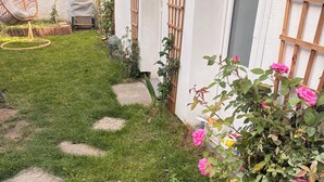 Ein Garten mit Kieswegen, einem Schaukelstuhl und einem Rosenbusch.