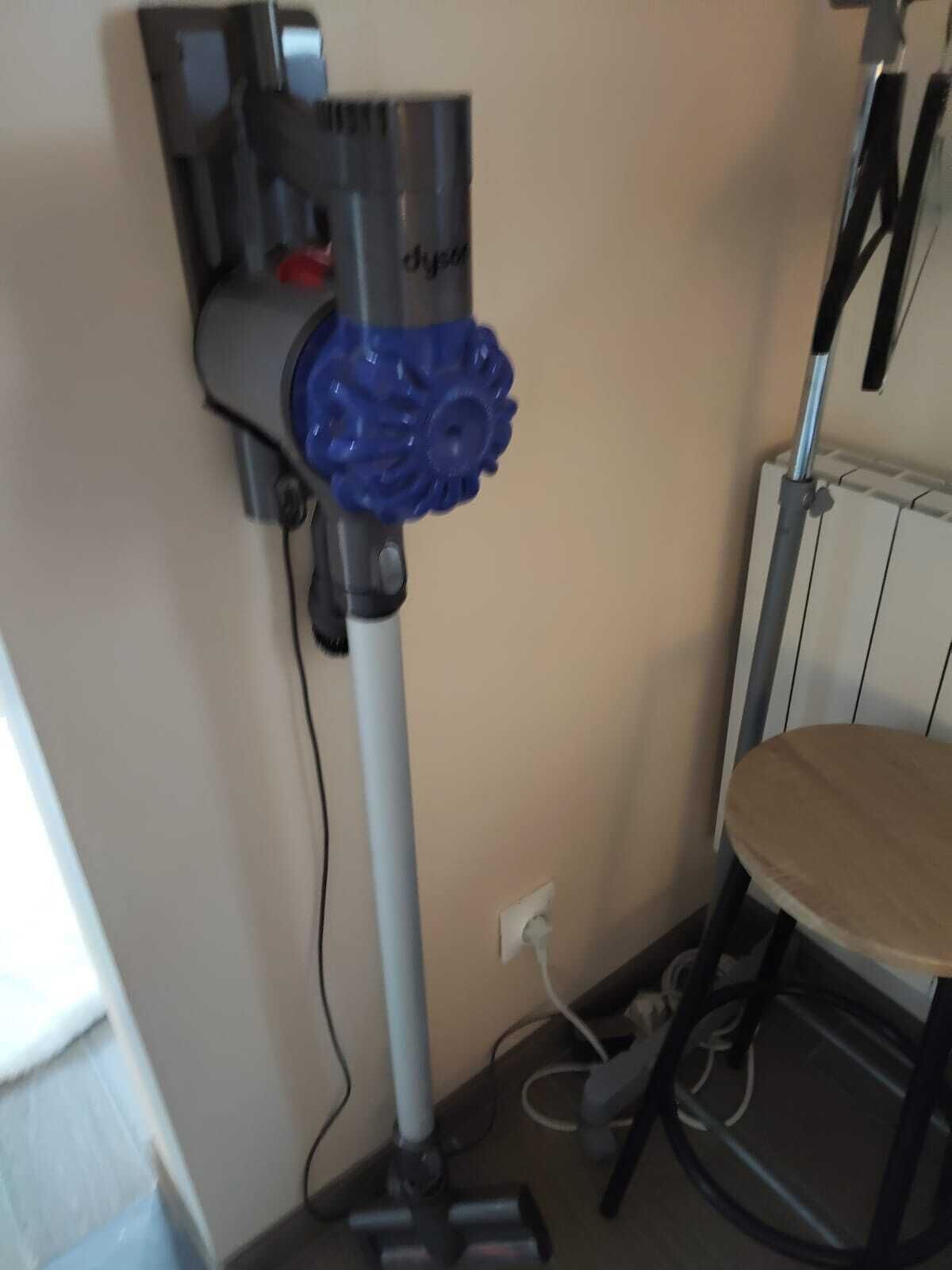 Un coin de pièce avec un radiateur, une chaise et une prise de courant au mur.