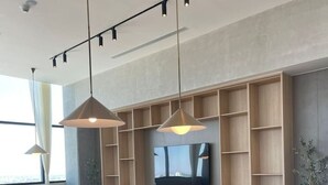 A modern pool table in a room with a large window, a TV mounted on the wall, and a wooden shelving unit. - Great New Modern Department Expo GDL (Guadalajara)