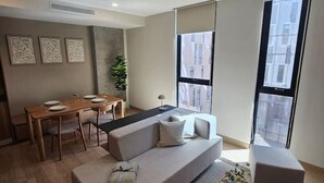 A modern living room with a sofa, coffee table, and dining area. - Great New Modern Department Expo GDL (Guadalajara)