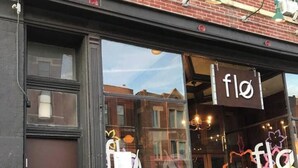 A storefront with a sign reading "flo" and colorful graffiti on the window. - Spacious loft in the heart of West Town, Noble Square Chicago (Chicago)
