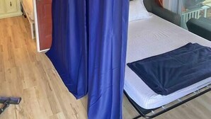 Un dormitorio con cama, cortinas, una ventana y vistas al exterior.