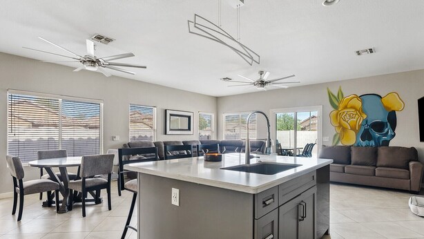 A modern kitchen with a central island, built-in appliances, and a dining area with a table and chairs. - Amazing Gilbert Retreat (Gilbert)