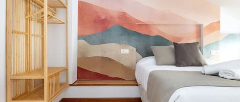 A bedroom with a bed, a wooden shelf unit, and a wall mural.