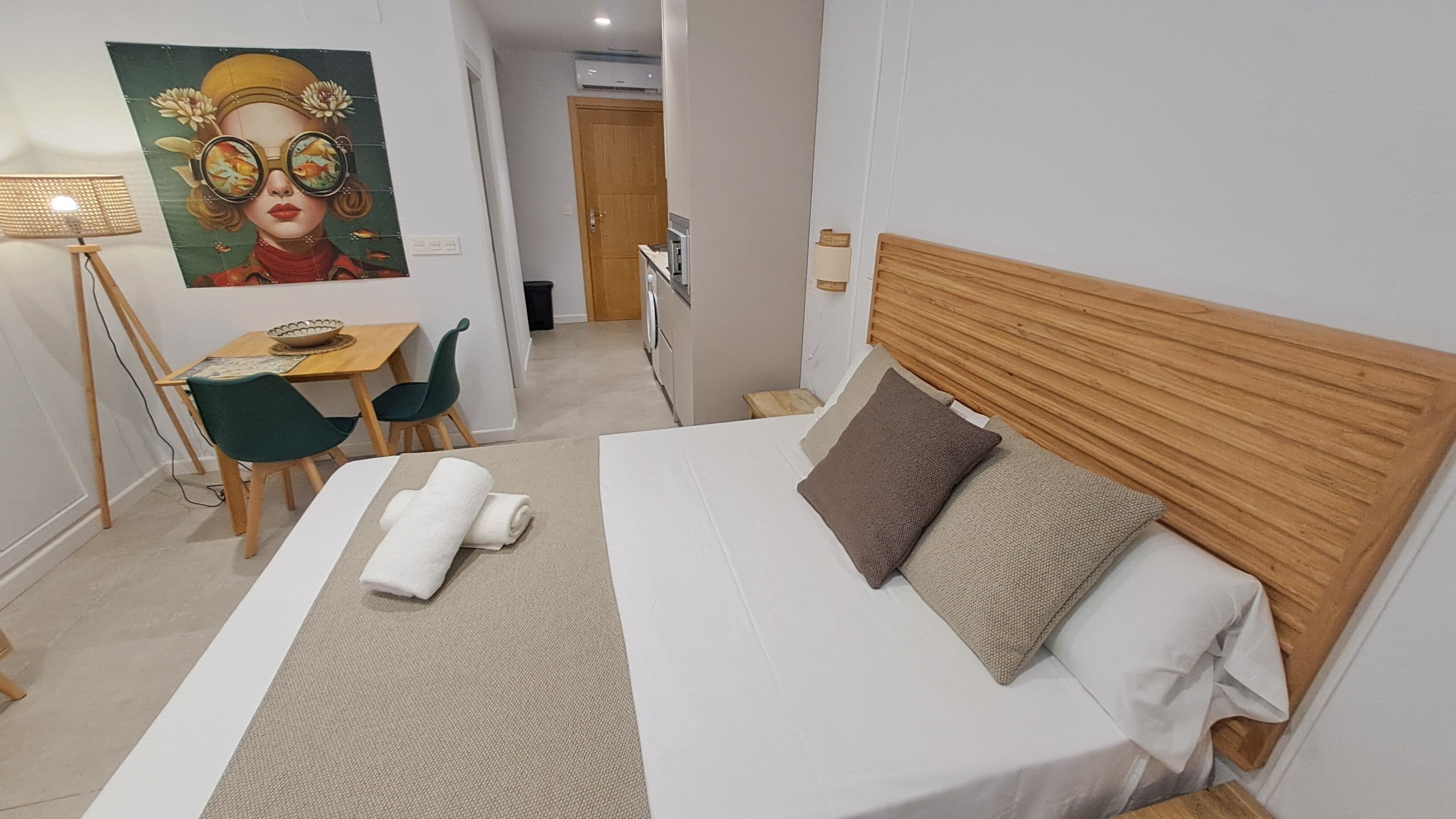 Ett välordnat hotellrum med en säng, ett skrivbord och en stol.