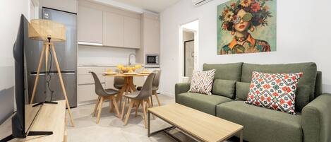 A modern living room with a sofa, coffee table, and dining area.