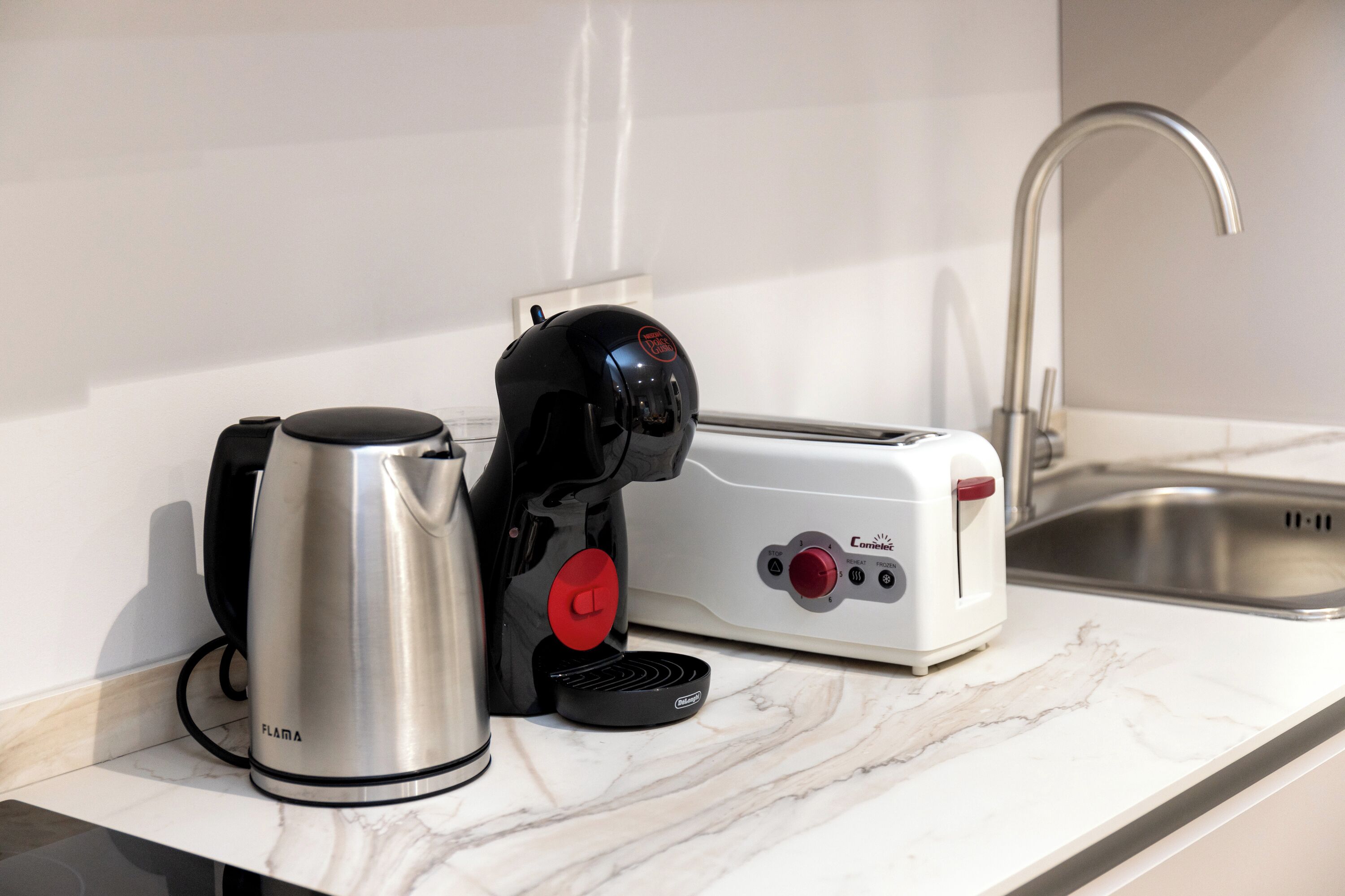 Un plan de travail de cuisine avec une machine à café, un grille-pain et une bouilloire.