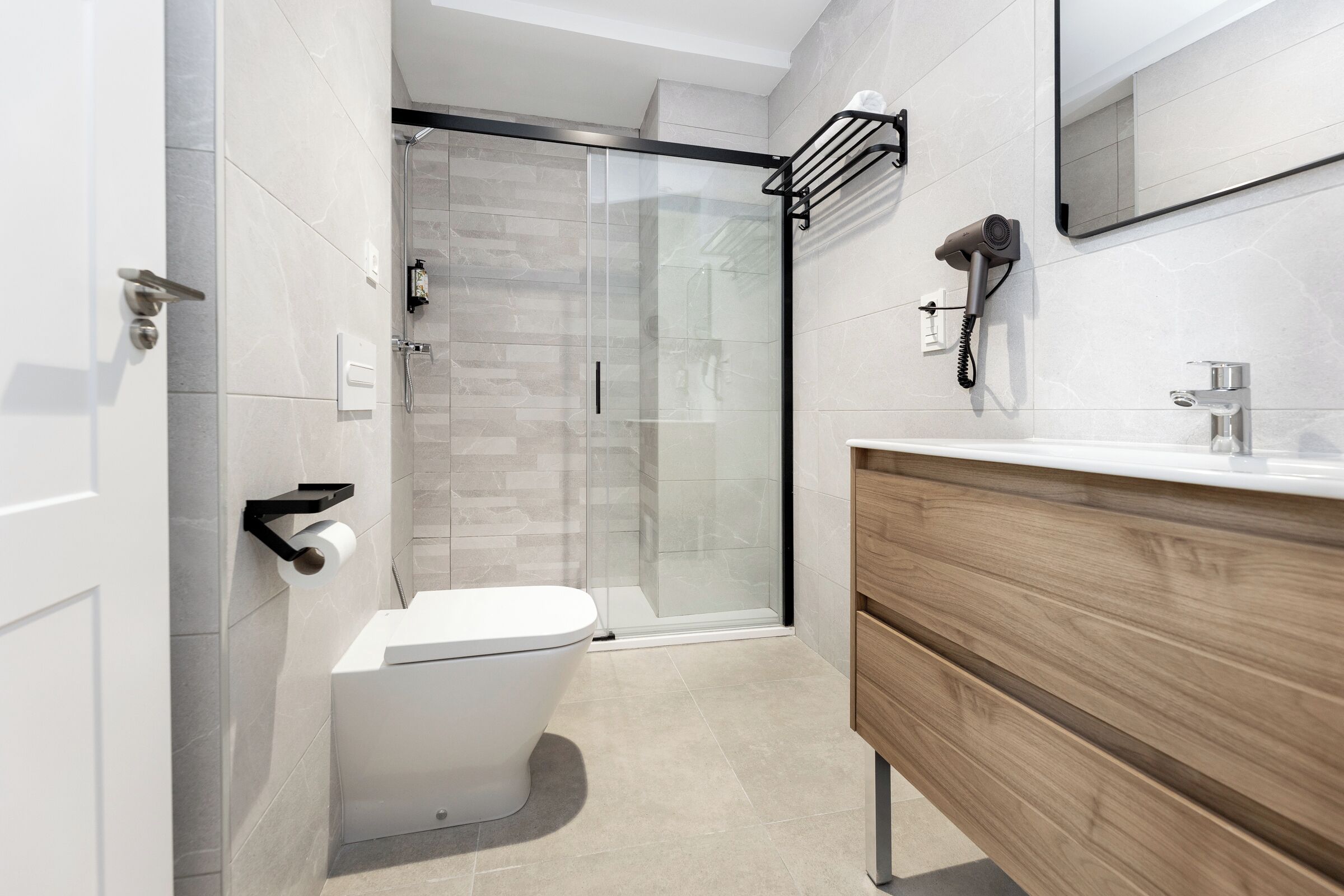 Un baño moderno con inodoro, ducha y tocador.