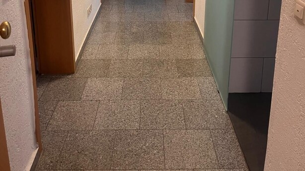 A hallway with tiled flooring, wooden doors, and a view of a dining area in the distance. - NR 3 Apartment on the upper floor 3 ZKB for companies/families (Vellmar)