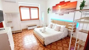 A bedroom with a bed, a TV, a window, and a wall-mounted shelf. - Villa Lea - Apartments Torre dell'Orso (Torre dell'Orso)