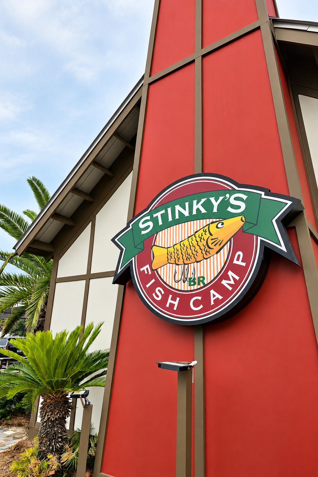 Ein Gebäude mit roter Fassade und einem Schild, auf dem 'Stinky's Fish Camp' steht.