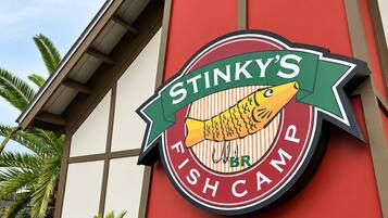 Ein Gebäude mit roter Fassade und einem Schild, auf dem 'Stinky's Fish Camp' steht.