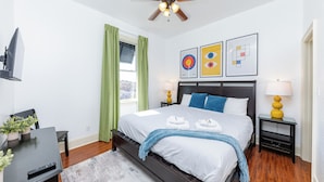A bedroom with a bed, a ceiling fan, a TV, a desk, and a window with curtains. - Modern King bed Haven/Free parking, Pool, Balcony (Santa Rosa Beach)
