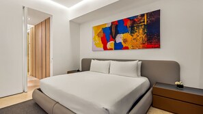 A modern bedroom with a large bed, a nightstand, a dresser, and a colorful abstract painting on the wall.