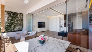 Una sala de estar moderna con una mesa de mármol, un sofá y un televisor.
