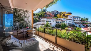 A balcony with a view of colorful buildings and lush greenery.