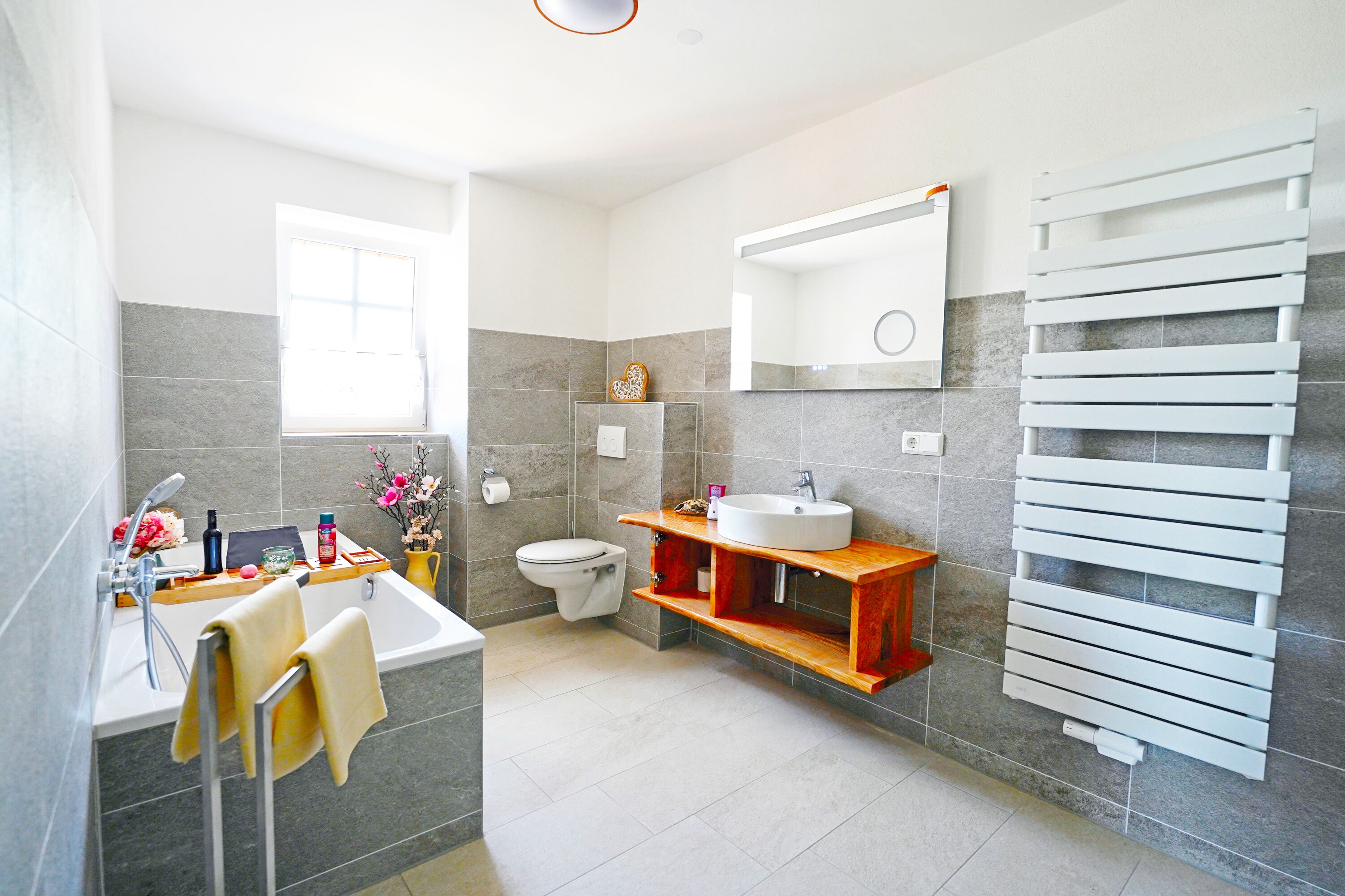 A modern bathroom with a bathtub, toilet, sink, and towel rack.