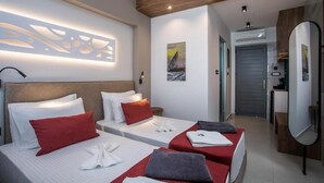 Ein Hotelzimmer mit zwei Betten, einem großen Spiegel und Bildern an den Wänden.