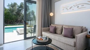Ein modernes Wohnzimmer mit Sofa, einem kleinen Tisch und Blick auf einen Swimmingpool.