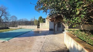 A courtyard with a swimming pool, stone walls, and a building with a wooden roof. - Private swimming pool - Charming Quercy stone house (Roquecor)