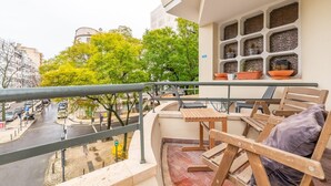 A balcony with a view of a city street, a table, and chairs. - GuestReady - A comfortable stay in Lisbon (Lisbon)