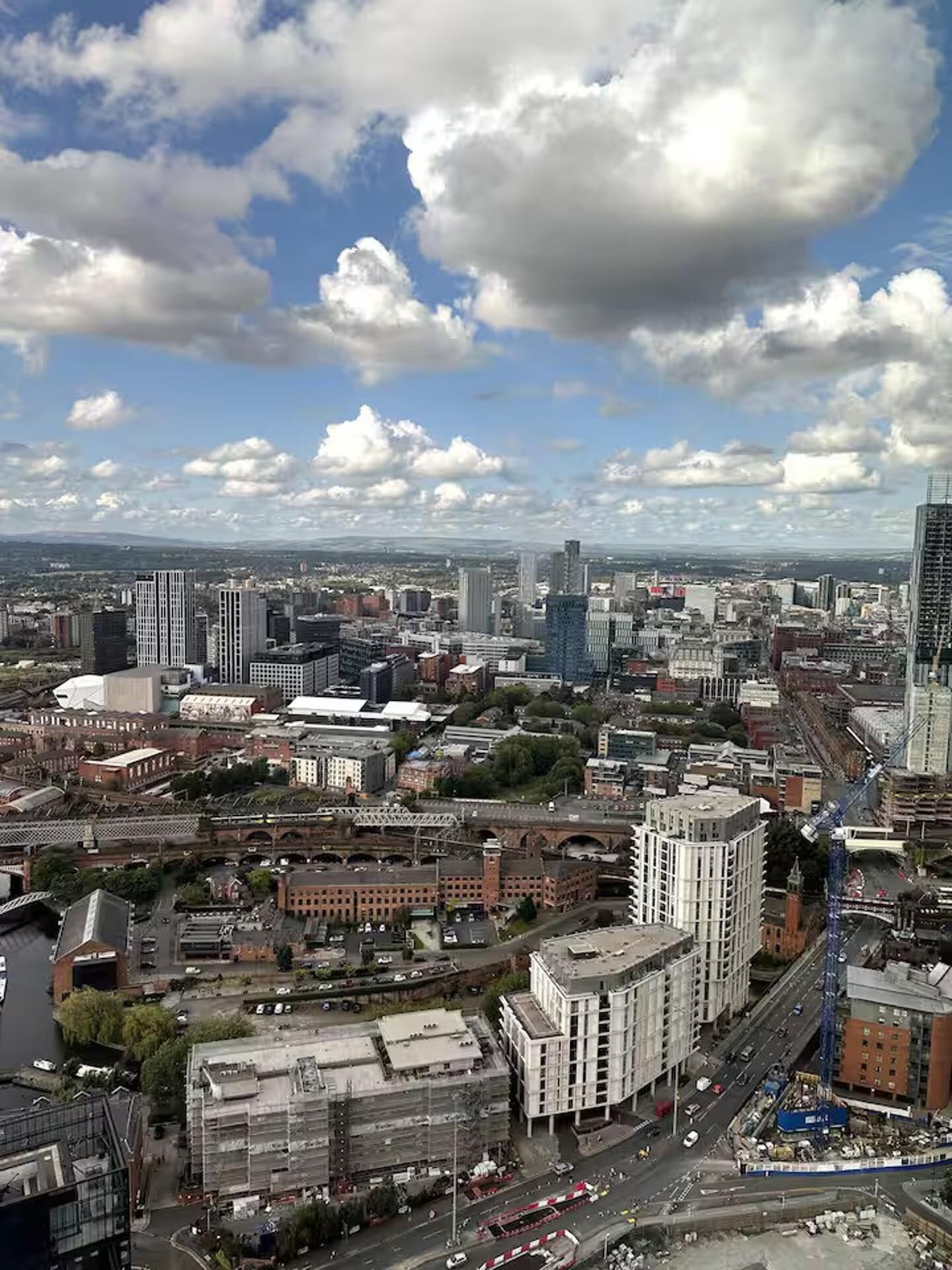 A cityscape with a mix of modern and older buildings, a river, and a bridge.