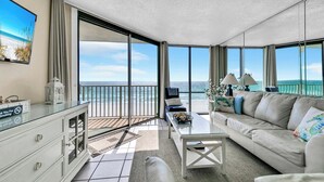 A spacious living room with a large glass door leading to a balcony overlooking the sea. - ⛱️Stunning Beach Front Views-11 Pools-Leeward 403 at Edgewater⛱️ (Panama City)