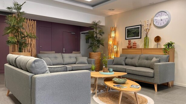 A modern living room with grey sofas, a wooden coffee table, and decorative plants. - Zenao Appart'hôtels Challans (Challans)