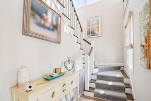 A staircase with a carpeted landing and a wall-mounted picture frame. - Bethany Beach Waterfront Oasis! (South Bethany)