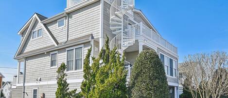 A two-story house with a prominent front staircase and a balcony.