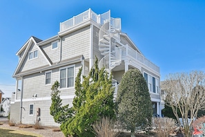 A two-story house with a prominent front staircase and a balcony. - Bethany Beach Waterfront Oasis! (South Bethany)
